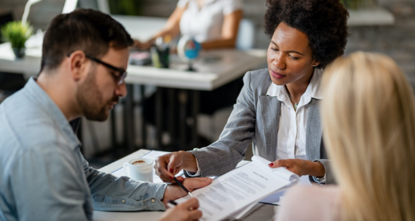 Three people talking and looking at paperwork