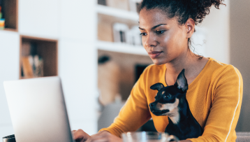 woman banking online with dog in her lap
