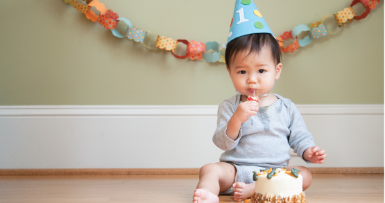 a baby eating cake on his first birthday
